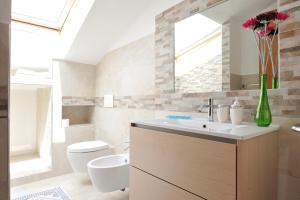 une salle de bain avec un lavabo, des toilettes et un miroir dans l'établissement Casa Vacanze Mameli, à Bari Sardo 65 autres photos