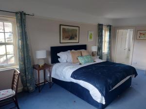 a bedroom with a large bed and two windows at Hawks Nest in Selkirk
