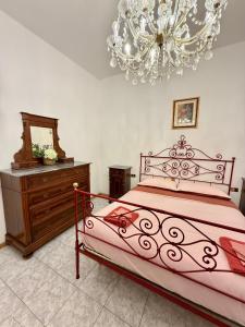 a bedroom with a large bed and a chandelier at House of Arcadia in Pistoia