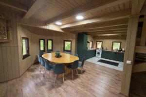 a dining room with a wooden table and chairs at Everwood Lodge, Transylvania in Sub Cetate