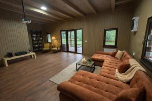 a large living room with a couch and a table at Everwood Lodge, Transylvania in Sub Cetate