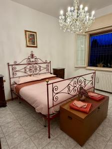 a bedroom with a large bed and a chandelier at House of Arcadia in Pistoia