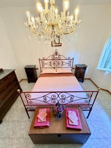 a bedroom with a large bed and a chandelier at House of Arcadia in Pistoia
