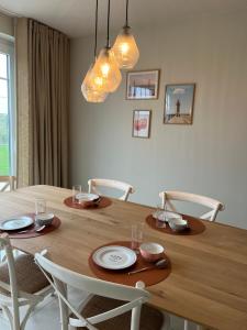 a wooden table with chairs and a dining room at Noordzeehuys in Middelkerke