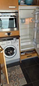 an open refrigerator with a washing machine in it at Studio les Trois Etoiles de Mer in Concarneau