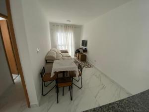 a living room with a couch and a table at Atlântico 34 Guilhermina in Praia Grande