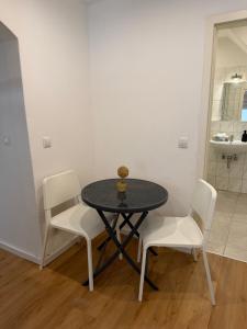 a table with two white chairs and a table with a bowl on it at Tuvalu in Remagen