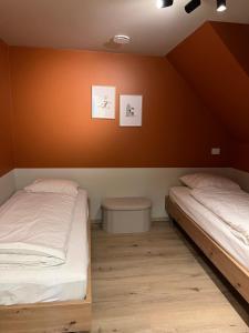 two beds in a room with orange walls at Noordzeehuys in Middelkerke