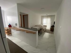 a white living room with a couch and a mirror at Atlântico 34 Guilhermina in Praia Grande +12 photos