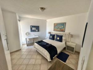 a bedroom with a bed with blue pillows at Sand And Sea Self Catering #3 in Swakopmund