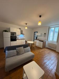 a living room with a couch and a kitchen at Petite rivière in Nantes