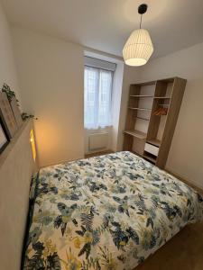 a bedroom with a bed with a floral bedspread at Petite rivière in Nantes