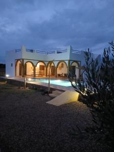 a large house with a swimming pool at night at Chambres Maison d'hôtes MaisonBlanche in Essaouira