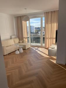 a living room with a couch and a large window at Apartamenty Sady in Słubice