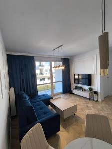 a living room with a blue couch and a table at Apartamenty Sady in Słubice