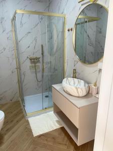 a bathroom with a glass shower and a sink at Apartamenty Sady in Słubice