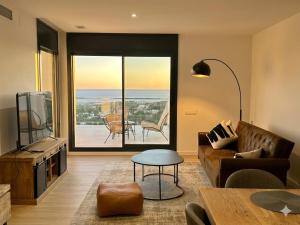 a living room with a couch and a large window at Les Flors de Cunit Villa Edelweiss in Cunit +44 photos