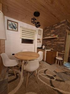 a kitchen with a wooden table and white chairs at Straza in Rožanstvo