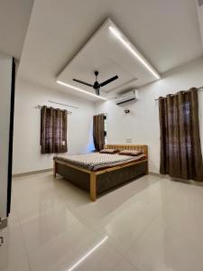 a bedroom with a bed and a ceiling fan at Nisarg Homestay with Kitchen Dinning in Bhuj
