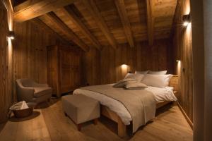 a bedroom with a large bed and a chair at Lavarets Chambres d’Hôtes in Ayas