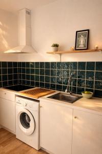 a kitchen with a washing machine and a sink at Apartamento Gades Conil C in Conil de la Frontera +6 photos
