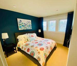 a bedroom with a bed and a blue wall at Qualicum Landing Paradise in Qualicum Beach +6 photos