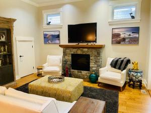 a living room with a fireplace and a flat screen tv at Qualicum Landing Paradise in Qualicum Beach