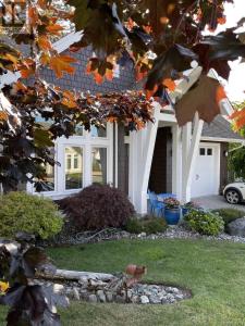 a bird standing in the grass in front of a house at Qualicum Landing Paradise in Qualicum Beach