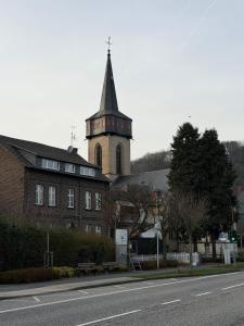 a building with a tower and a church with a street at Arcadia in Remagen +4 photos