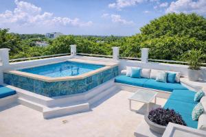 a swimming pool on a patio with blue furniture at Mansion Mauresque in Playa del Carmen