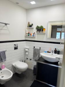 a white bathroom with a toilet and a sink at Full casa 1 in Cosenza