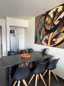 a dining room table with chairs and a painting on the wall at Full casa 1 in Cosenza