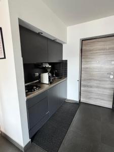a kitchen with black cabinets and a sliding door at Full casa 1 in Cosenza +12 photos