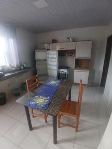 a kitchen with a table and two chairs and a table and a kitchen at Pousada JC 50 in Santarém +13 photos