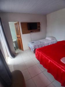 a room with two beds and a television in it at Pousada JC 50 in Santarém