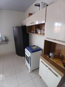 a small kitchen with a stove and a refrigerator at Pousada JC 50 in Santarém