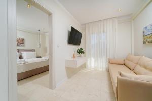 a living room with a couch and a bedroom at Synthea Suites in Chrysi Ammoudia