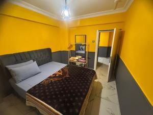 a bedroom with a bed and a yellow wall at İlkadım Suit Apart in Samsun +2 photos