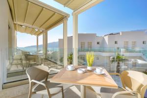 a table and chairs on a balcony with a view at Synthea Suites in Chrysi Ammoudia