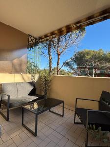 a patio with a couch and tables on a balcony at SeaNest Le Nid Marin in Saint-Raphaël +4 photos