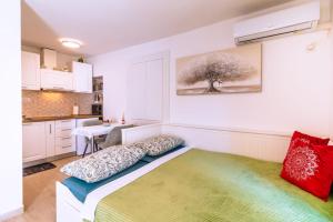 a bedroom with a bed and a kitchen at Studio apartman Relota in Kaštela