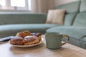a plate of donuts and a cup of coffee on a table at Apartament Miętowy Kwidzyn in Kwidzyn
