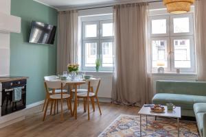 a living room with a table and chairs and a couch at Apartament Miętowy Kwidzyn in Kwidzyn