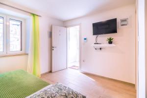 a bedroom with a bed and a television on a wall at Studio apartman Relota in Kaštela