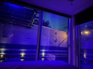 a purple room with a bed and a window at Cancún Hotel Boutique & Hostel in Cancún