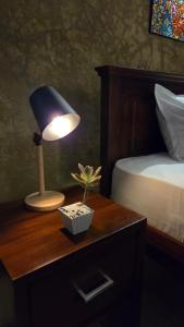a lamp on a table next to a bed with a plant at Casa Jose - 2BR with King Beds, Near Airport and Beach, 5G Wi-Fi in Wattala