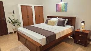 a bedroom with a large bed and a night stand at Casa Jose - 2BR with King Beds, Near Airport and Beach, 5G Wi-Fi in Wattala