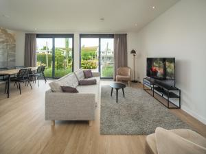 a living room with a couch and a dining room at Harderwold Villa - 228 in Zeewolde