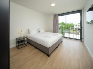a bedroom with a bed and a large window at Harderwold Villa - 228 in Zeewolde