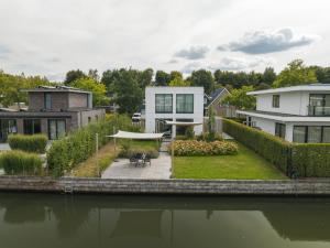 a house with a garden and a river at Harderwold Villa - 228 in Zeewolde